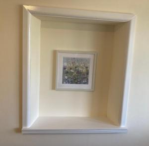 a framed picture of flowers on a wall at Ashes Farm Cottage in Kilmington