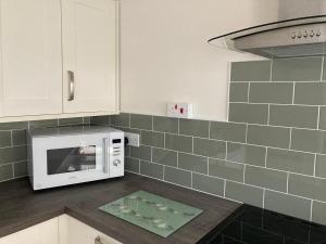 a kitchen with a white microwave on a counter at Ashes Farm Cottage in Kilmington