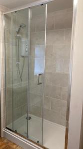 um chuveiro com uma porta de vidro na casa de banho em Ashes Farm Cottage em Kilmington