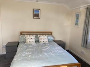 Ashes Farm Cottage في Kilmington: غرفة نوم مع سرير مع وسادتين