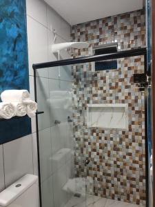 uma casa de banho com uma cabina de duche em vidro e um WC. em Casa em Alter do Chão - Nosso Canto em Santarém