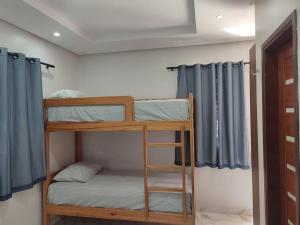 聖塔倫的住宿－Casa em Alter do Chão - Nosso Canto，配有蓝色窗帘的客房内的两张双层床
