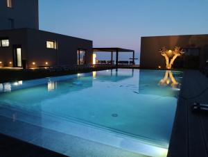a swimming pool with a statue on the side of a building at Hotel Punta Tipa in Trapani
