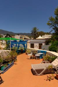 a patio with chairs and tables on a roof at Hostel Albergue La Casa Encantada in El Paso +51 photos
