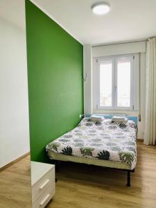 a bedroom with a bed with a green wall at Venice Mestre Station House in Mestre