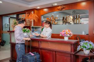 a man and a woman standing at a cash register at DUC MINH HOTEL in Ho Chi Minh City