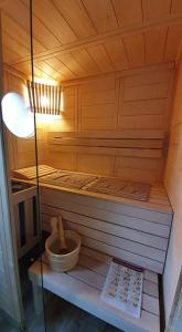 uma pequena sauna de madeira com uma tigela e uma luz em Bulles d'un soir Gite SPA em Ruminghem