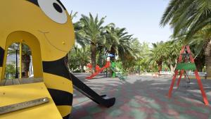 un parque infantil con tobogán en un parque con palmeras en Casa Rural La Tahona, en Elche de la Sierra