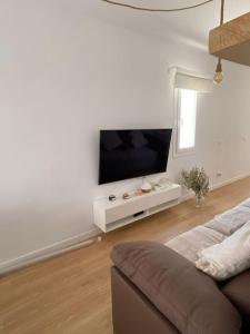 sala de estar con sofá y TV de pantalla plana en Apartamento en Vilanova, Ático, en Vilanova i la Geltrú