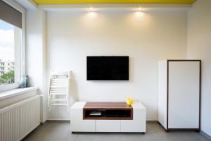 a living room with a tv on a white wall at Studio Świętojańska in Gdynia