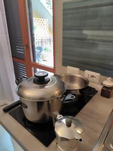 'La perla del lago' alloggio turistico في ترفيجنانو رومانو: مطبخ مع قدور ومقالي على موقد