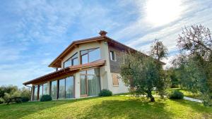 ein Haus mit einem großen Fenster auf einem Grasfeld in der Unterkunft Agriturismo Fioralba in Polpenazze del Garda