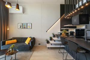 a kitchen and living room with a couch and a table at KODA LOFT EXTENDED - Urlaub im Tiny House Bodensee in Lauterach