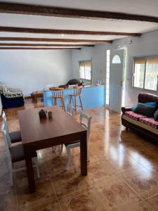 a living room with a table and chairs and a kitchen at Open Mind Hostel in Alcalá la Real