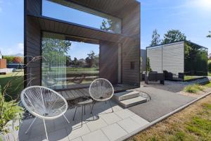 a glass house with two chairs and a table at KODA LOFT EXTENDED - Urlaub im Tiny House Bodensee in Lauterach