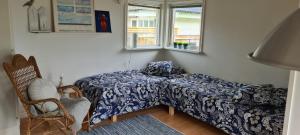1 dormitorio con 1 cama, 1 silla y 1 ventana en Havsnärastugan en Öckerö