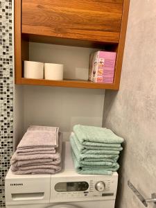 una lavandería con una pila de toallas y una lavadora en Cozy Independent guest house, free parking, en Tomaszów Mazowiecki