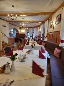 une rangée de tables dans un restaurant avec des serviettes rouges dans l'établissement Hotel Restaurant Liesele Sonne, à Sankt Leonhard im Pitztal