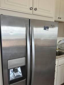 um frigorífico de aço inoxidável numa cozinha com armários brancos em Hampton Beach OCEAN FRONT Condo at the Surf em Hampton