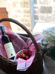 a basket with a bottle of wine and strawberries at Mansarda apartment in Kotor