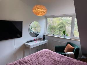 - une chambre avec un lit, une télévision et une fenêtre dans l'établissement Hus nära bad ,golf ,nöjen , gym och natur., à Askim