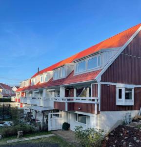 um edifício com telhado vermelho e telhado vermelho em Hus nära bad ,golf ,nöjen , gym och natur. em Askim