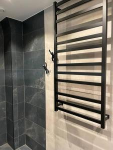 La salle de bains est pourvue d'une douche avec un mur noir. dans l'établissement Hus nära bad ,golf ,nöjen , gym och natur., à Askim
