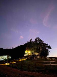 um celeiro iluminado à noite num campo em Rancho Sol Poente - Rancho Queimado - SC em Rancho Queimado