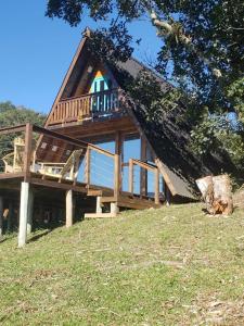 uma casa com um deque no topo de uma colina em Rancho Sol Poente - Rancho Queimado - SC em Rancho Queimado