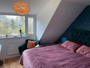 una camera con letto viola e finestra di Hus nära bad ,golf ,nöjen , gym och natur. a Askim