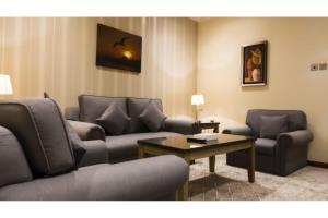 a living room with a couch and chairs and a table at Capital O 126 Manama Tower Hotel in Manama