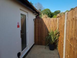 a door to a fence with a plant next to it at The Coppice-Private Studio Guest Suite With Private Entrance in Watford