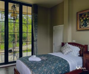 um quarto com uma cama e uma grande janela em VANA Homestay em Ban Tai