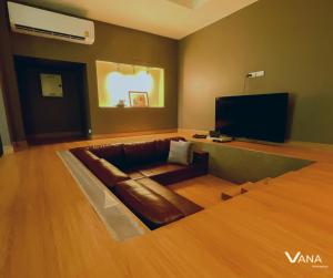 VANA Homestay في Ban Tai: غرفة معيشة مع أريكة وتلفزيون