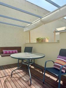 a table and two chairs on a deck with a table at La Casa de la Alameda in Málaga