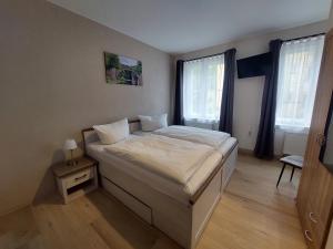 um quarto com uma cama grande e 2 janelas em Pension Am Park em Bad Muskau