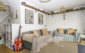 a living room with a couch and a guitar at STYLISH CHALET with SEA VIEWS at Kingsdown Park with Swimming POOL in Kingsdown