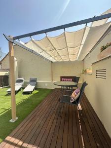 a patio with a table and chairs on a deck at La Casa de la Alameda in Málaga