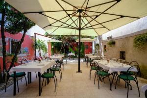 a restaurant with tables and chairs under an umbrella at Locanda Il Cavallino in Valeggio sul Mincio