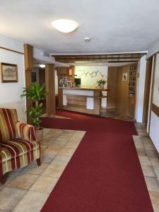 vestíbulo con alfombra roja y sala de espera en Hotel Restaurant Liesele Sonne en Sankt Leonhard im Pitztal