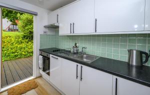 a kitchen with white cabinets and a sink at STYLISH CHALET with SEA VIEWS at Kingsdown Park with Swimming POOL in Kingsdown