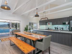 Una cocina y un comedor con mesa y sillas de madera. en Stunning Villa with pool and views of Knysna, en Knysna