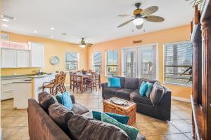 a living room with two couches and a kitchen at Villa Laguna! STEPS to the pool & lagoon views, with boardwalk to beach in Port Aransas