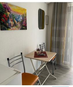 a table and chairs in a room with a painting at Guest House Zarnovel Palace in Ohrid