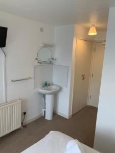 ein Badezimmer mit einem weißen Waschbecken und einem Spiegel in der Unterkunft St Merryn in Carbis Bay