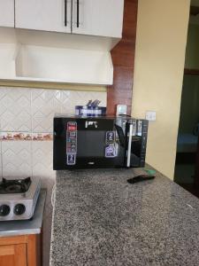 - une cafetière sur un comptoir dans la cuisine dans l'établissement G&G Westindies Executive One Bedroom, à Eldoret