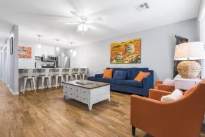 a living room with a blue couch and a kitchen at Wave on Wave! Overlooking community pool! in Port Aransas