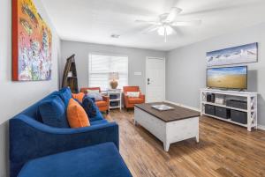 a living room with a blue couch and a tv at Wave on Wave! Overlooking community pool! in Port Aransas