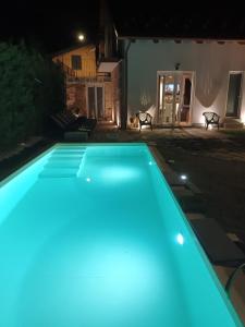 uma piscina à noite com luzes azuis em Villa Celeste em Murazzo