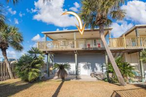 a house with palm trees in front of it at Wave on Wave! Overlooking community pool! in Port Aransas